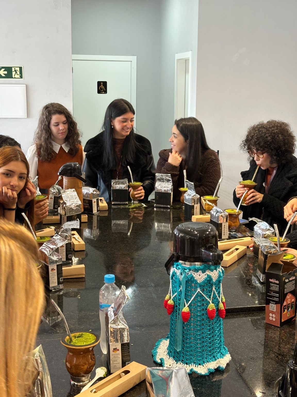 Pessoas conversando ao redor da mesa com chimarrão em Torres